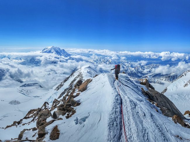 A climber on 16 ridge with 14 Camp below and Mount Foraker in the background. Photo by Jason Denley
